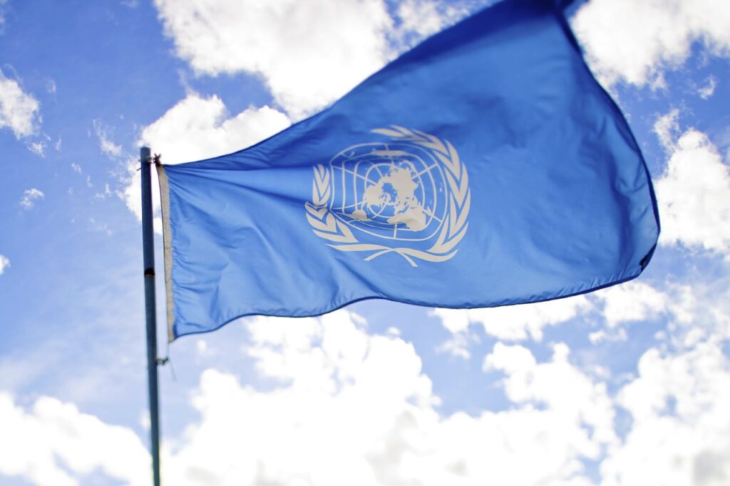 Flagge der UN am Mast, wehend im Wind